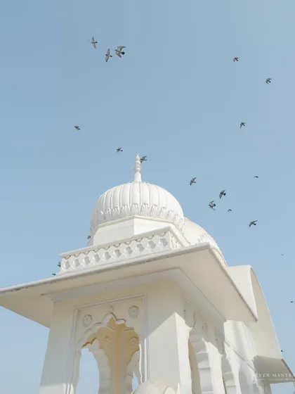 The simple elegance of a white dome against a clear blue sky. I often use architectural details like this to set the scene and establish the aesthetic of a wedding location, creating a sense of peace and grandeur.