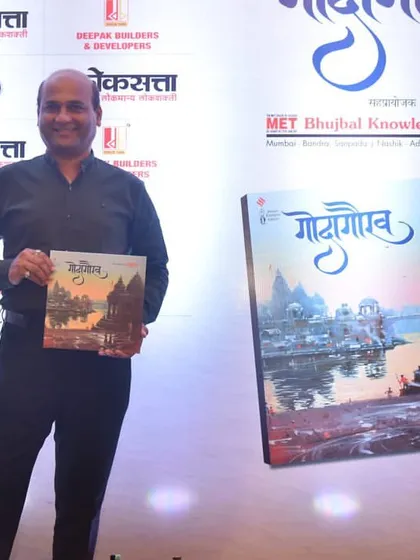 Posing next to a large display of the "Godagaurav" book cover at the launch event.