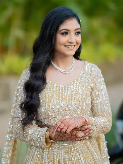 A full-length view of the bride in her golden lehenga. The makeup is elegant and timeless.