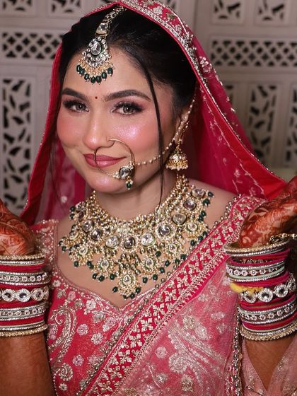 Our gorgeous bride, happy and glowing. The hands are up, showing off her beautiful henna and bridal bangles, a complete picture of bridal joy.