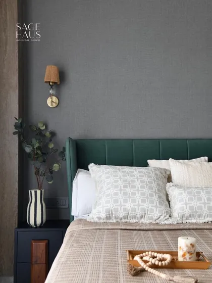 This bedroom balances plush textures, soft lighting, and earthy accents. The deep green headboard adds character and depth, while the layered neutral bedding brings softness, proving that a minimal aesthetic can still be full of personality.