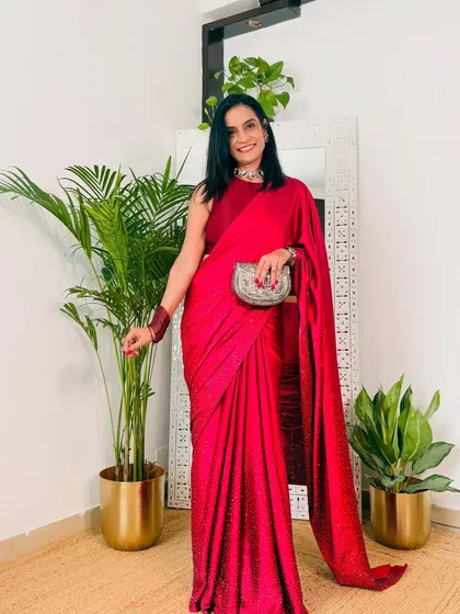 This solid magenta satin saree has a beautiful shimmer, making it perfect for evening parties or receptions. Paired with a silver clutch, it creates a very sophisticated party look.
