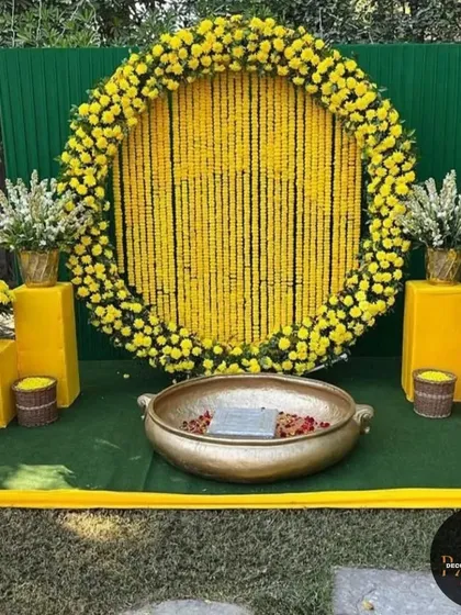 A popular choice for Haldi decor, this circular backdrop is made entirely of marigold strings, creating a vibrant wall of yellow. The setup is completed with a large brass urli for the ceremony, perfect for a traditional and photogenic Haldi function.