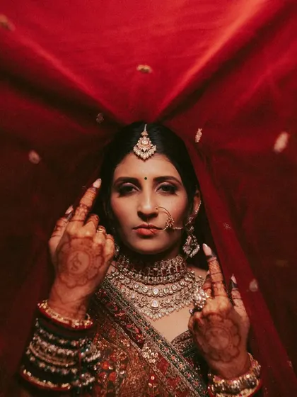 A bride with an attitude that we love to capture. This portrait under the red veil, combined with her grand entrance, tells the story of a modern bride who owns her moment.