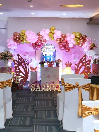 A view of the seating arrangement and main stage for a butterfly-themed party, showing how the decor transforms the entire space.
