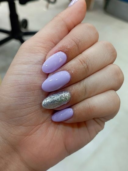 An accent nail is a great way to add sparkle without overwhelming the look. Here, I paired a soft lavender gel polish on oval nails with a single, full-coverage silver glitter nail for a chic and balanced manicure.