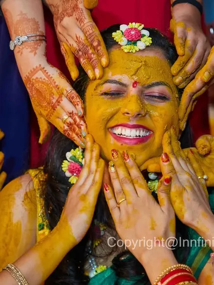 Capturing the pure, uninhibited joy of a bride during her Haldi ceremony. This tight shot focuses on her expression as friends and family apply the turmeric paste, a moment filled with laughter and tradition.
