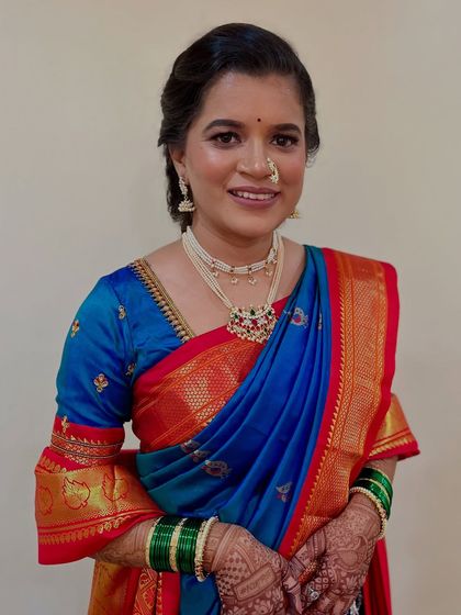 A natural and subtle look for a *Simantipoojan* ceremony. The client looks elegant and serene in her traditional blue and red saree.