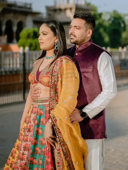 A classic couple portrait that showcases the beautiful details of their traditional outfits and the impressive architecture of the Albert Hall Museum.