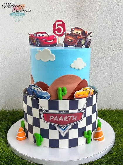 Ka-chow! This Disney Cars cake brings Lightning McQueen and Mater to the party. The design features a desert landscape and a checkered flag pattern, perfect for a high-energy birthday celebration for a young racing fan.