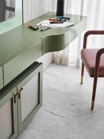 The study desk area within the master bedroom, showing the curved desk design and rattan-inlaid cabinet.