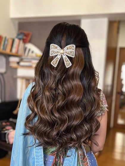 A final look at the beautiful bow hairstyle. The combination of soft waves and a statement accessory is a winning choice for any pre wedding event.