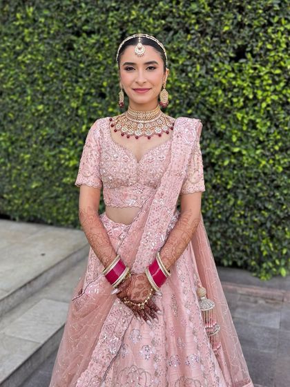 Aarushi was a vision in her pastel pink lehenga for her day wedding. We kept the makeup fresh and radiant, with a clean winged liner and a soft pink lip. These portraits capture the look from every beautiful angle.