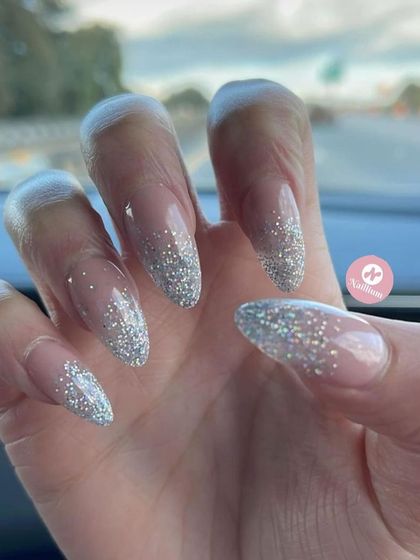 A simple yet stunning silver glitter fade on long, almond-shaped nails. This is my go-to for instant glam.