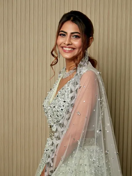 A beautiful shot capturing the joy and sparkle of the evening. The silver outfit and shimmering makeup are a match made in heaven.