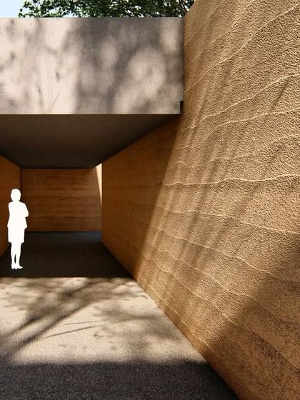 A rendering showing the entrance to the rammed earth retreat. The design creates a moment of compression, a narrow passage that opens up to the wider landscape, enhancing the experience of arrival.