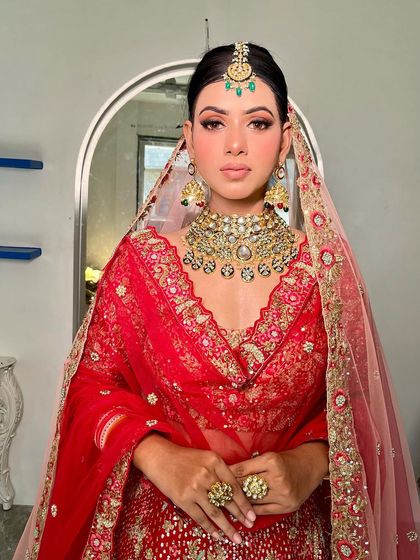 A full view of this regal bridal look. The statement necklace and matching tikka create a cohesive and royal aesthetic.