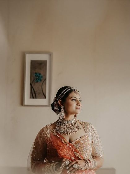A soft and dreamy bridal portrait. The out-of-focus foreground creates a sense of intimacy, drawing all attention to the bride's calm and beautiful expression.
