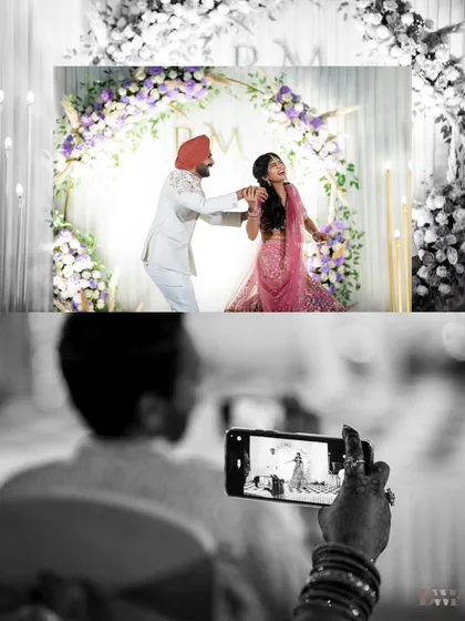 A creative black and white shot capturing a guest recording the couple's first dance. It tells a story within a story, highlighting the joy shared by everyone.