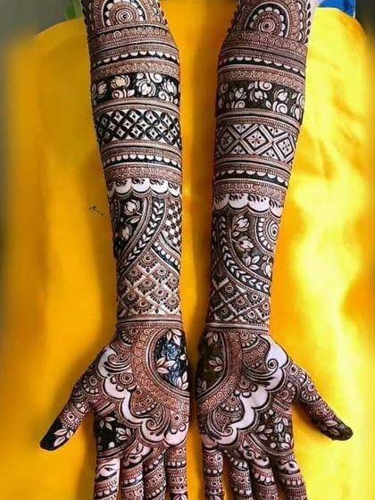 This is a duplicate of image 11. A stunning example of symmetrical bridal mehndi. The intricate checkerboard patterns and bold floral bands create a captivating and balanced design across both arms.
