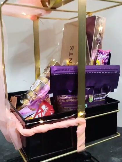 A close-up look inside the metal bow hamper, showing the variety of chocolates included. It's a perfect gift for any occasion that calls for a sweet celebration.