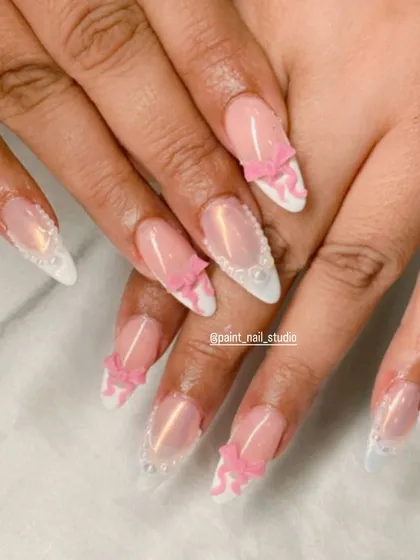Another angle of the pink and white 3D bow Christmas nails. The addition of tiny pearls along the French line adds an extra touch of elegance.