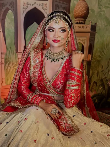 A regal pose showcasing the full bridal attire. The makeup is designed to complement the intricate details of the lehenga and jewelry.