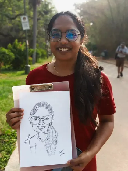 A full-shot of Hithaishini, proudly showing off her caricature.