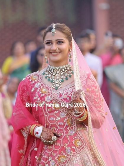 A graceful bride on her wedding day. Her delicate mehendi enhances her royal look without overpowering it, perfectly complementing her pink lehenga and stunning jewelry.