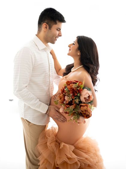 A beautiful high-key shot of the couple looking at each other. The soft peach gown and the bouquet add a touch of romance.