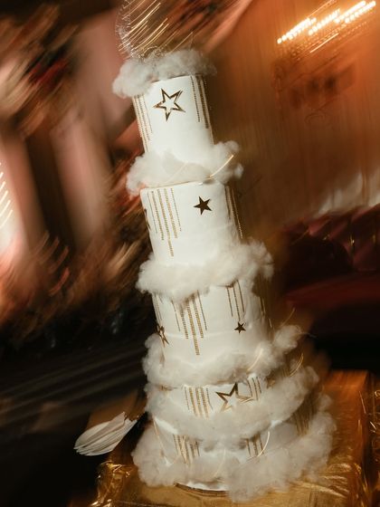 An artistic, motion-blur shot of the multi-tiered wedding cake. This creative technique gives the image a dreamy, magical quality, befitting a fairytale celebration.