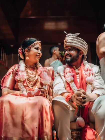 A candid moment between a bride and groom during their wedding ceremony, sharing a private smile that speaks volumes.