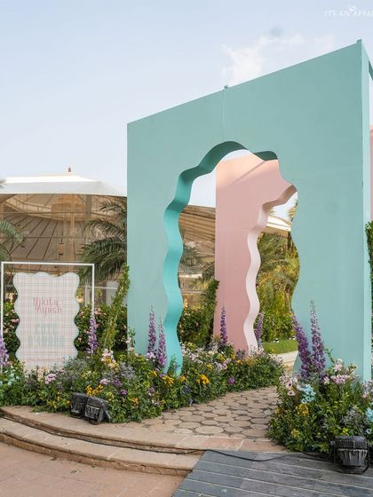 The whimsical entrance to our 'Côte d'Amour' mehendi, featuring wavy, pastel-colored arches that set a playful and artistic tone.