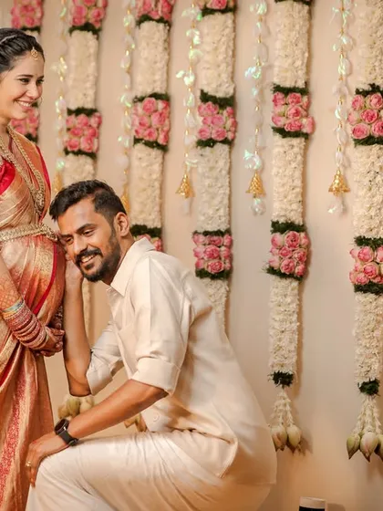 A classic, heartwarming moment between expecting parents during their traditional baby shower ceremony. We love capturing these sweet, unscripted interactions, like the dad-to-be listening to his baby against the backdrop of a lovely floral wall.