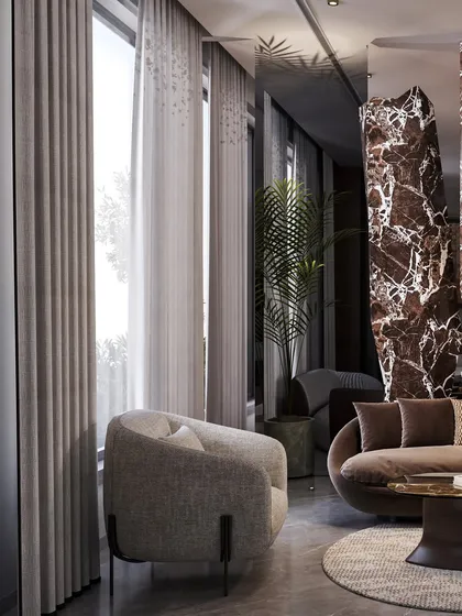 A dramatic, sculptural column clad in brown marble acts as a powerful divider between living spaces. This feature is both a functional separator and a piece of art, showcasing our use of bold materials to shape a home's architecture.