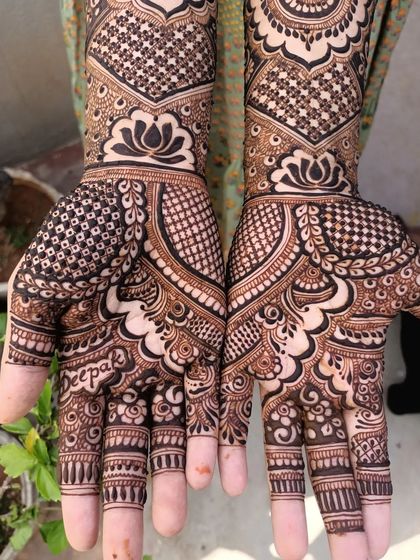 A beautiful example of personalization, with the groom's name, 'Deepak', elegantly written into the palm of the bride's hand.