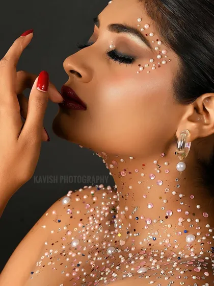 A profile shot that highlights the model's features and the unique pearl makeup, perfect for a fashion or beauty portfolio.