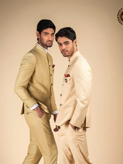 Two models showcasing our range of classic Bandhgala suits in shades of beige and cream, perfect for coordinating groomsmen looks.