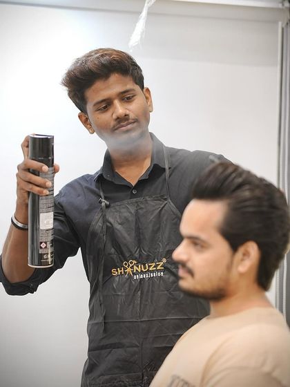 Here, one of my stylists is adding the finishing touches with hairspray to a wolf cut.