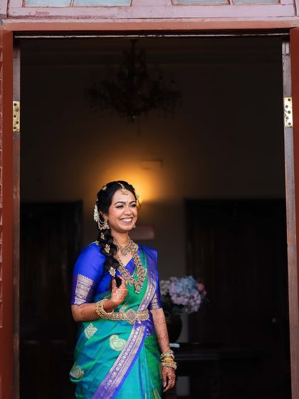 A full-length view of the bride's stunning look, showcasing the beautifully draped saree and traditional braided hairstyle.