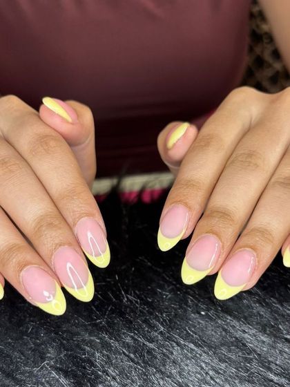 Bright and cheerful yellow French tips on almond-shaped nails, perfect for summer.
