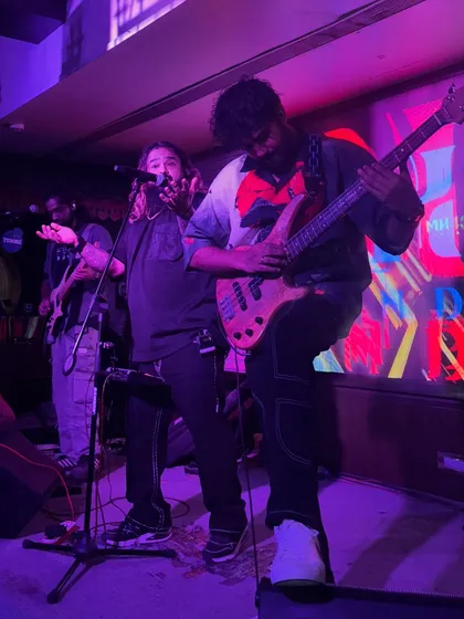 Our bassist and frontman rocking out together. The energy and camaraderie on stage are contagious, spreading right through the audience.