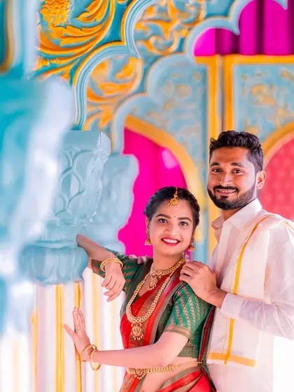 A couple in traditional attire poses against the vibrant backdrop of our Jaipuri palace set.