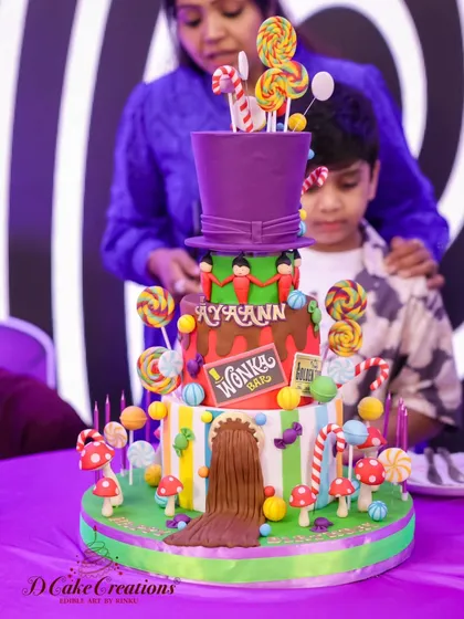 The birthday boy and his incredible four-tier Willy Wonka cake, complete with a chocolate river and a giant top hat.
