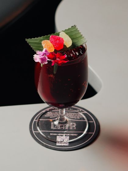 We turned a strawberry salad recipe into a cocktail called 'Not A Berry'. It features gin, balsamic, rhubarb, and a flat sparkling wine for a sweet, tangy, and unexpected flavor profile.