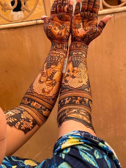 A unique over-the-shoulder view of a bride's full-arm mehndi, showing the intricate details from a different perspective.