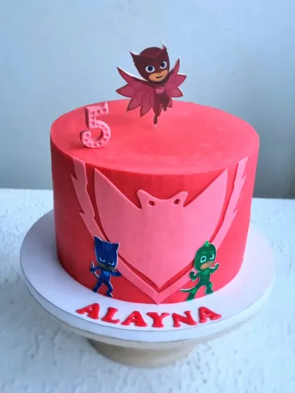 A bright red PJ Masks cake. This design uses fondant cutouts to create the character logos for a sharp, graphic look that kids love.