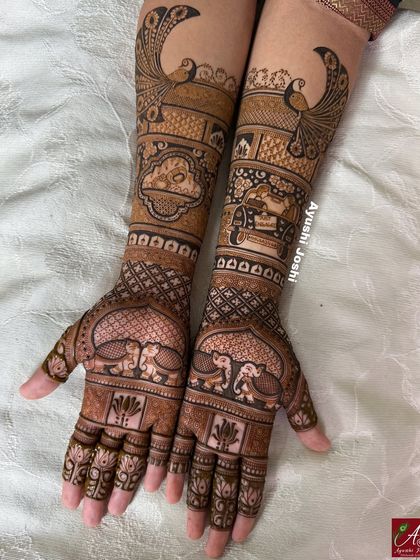 The completed custom engagement mehendi, showing the car drive scene on one arm and a ring ceremony motif on the other, surrounded by peacocks and elephants.