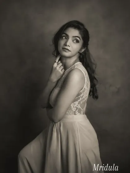 This black and white portrait of Mridula is pure vintage elegance. Her pose, looking away from the camera, combined with the soft, painterly light, creates a dreamy and nostalgic mood. The lace detail on her dress is beautifully rendered in monochrome.