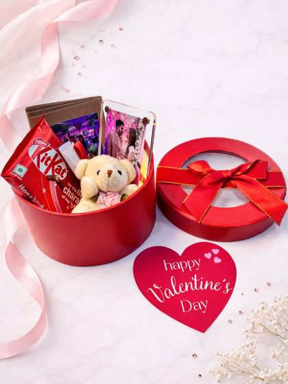 Small box, big emotions. This round red surprise box is perfect for Valentine's Day, holding a personalized photo, a teddy bear, chocolates, and love notes.